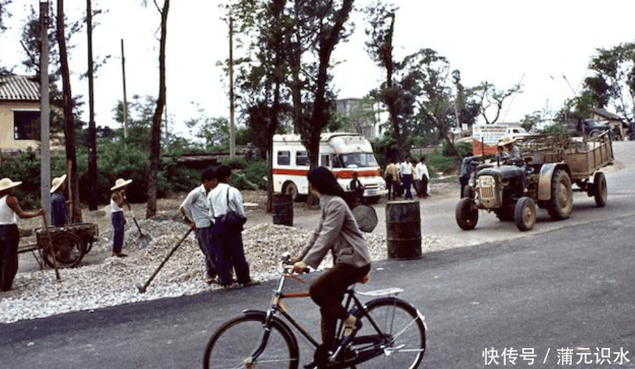 1980年中国历史老照片:1980年,深圳大街上骑自行车的路人看道路施工.