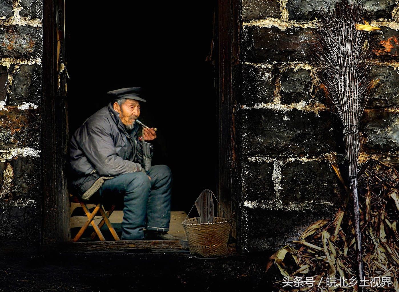 这是一名八旬皖北农村留守老人,图为老人坐在家门旁抽烟度日.