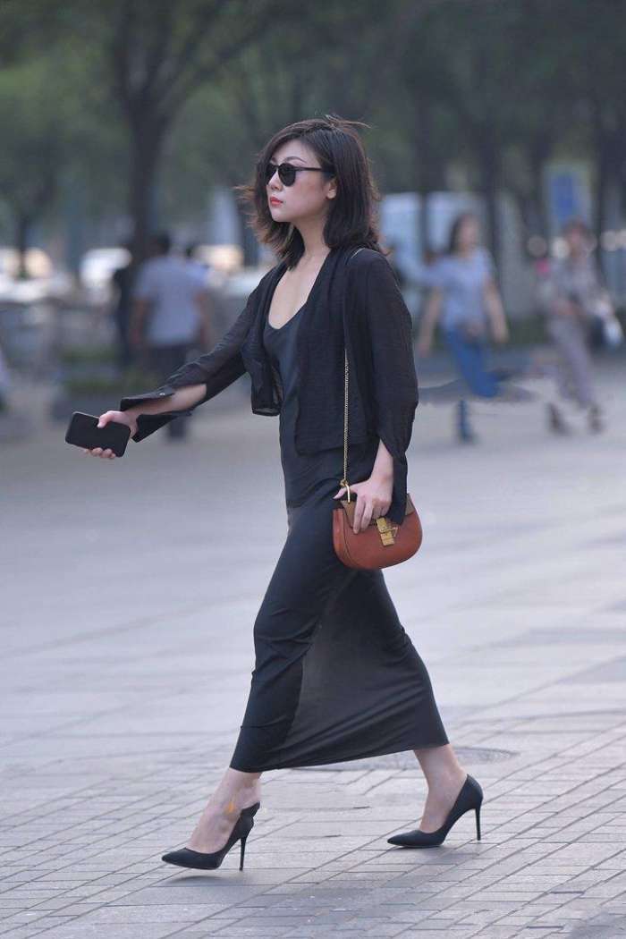 美女深色打扮, 透露出婀娜多姿的身段, 举手投足尽显魅力