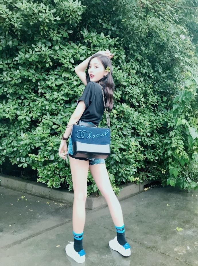 组图:吴宣仪与雨后绿植合影 长腿热裤笑容甜美清新可人