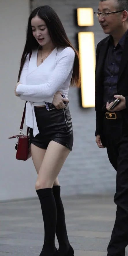 气质小姐姐黑色小皮裤包裹着肥硕性感的臀部，丰腴事业线走上街吸