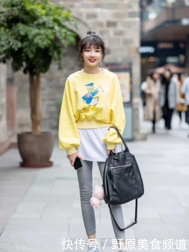 美女|街拍:黑色长袖衫和运动款式的打底裤,搭配很显腿长,打造出靓丽造型!