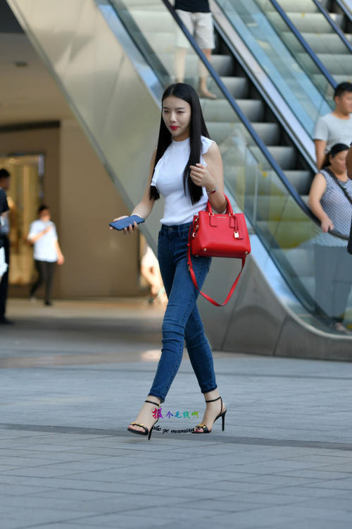 路人街拍，小姐姐紧身牛仔裤搭配白色无袖上衣，简单时尚的美！