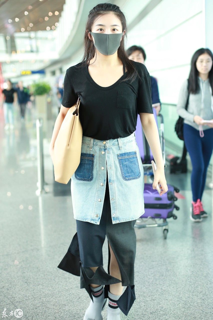 张含韵口罩遮面穿黑色T恤现身机场，下半身的时尚打扮让人看不懂