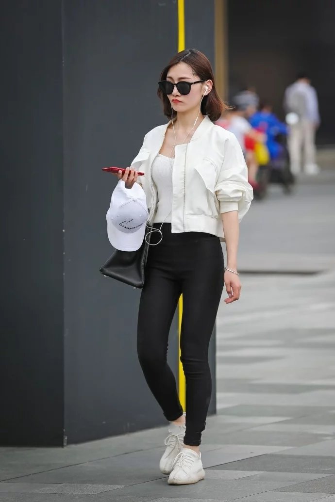 气质小姐姐黑色紧身裤绷出时尚美腿，一边走一边嘟嘴撩发萌态十足