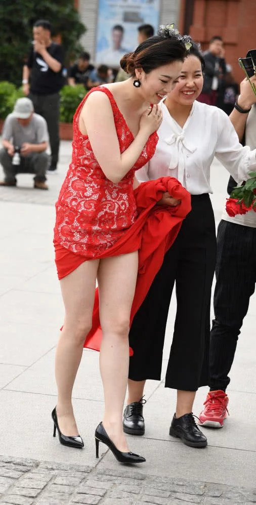 小姐姐穿红色嫁衣撩起裙摆秀出一双白皙美腿，笑容很幸福