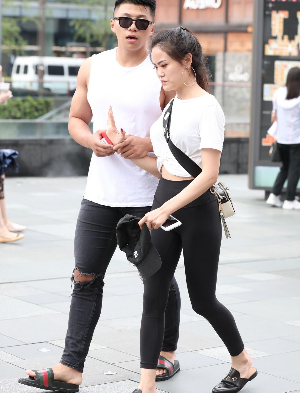 街拍:婴儿肥小姐姐紧身裤勾勒迷人线条，和肌肉男友出街像女王