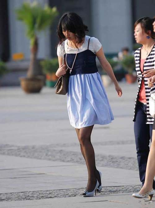 街拍：连衣裙裙下的丝袜大长腿妹子，一双细腿引人注目！