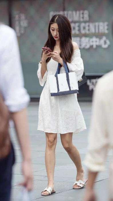 街拍: 小姐姐白色的吊带上衣,下身穿着黑色牛仔包臀裙,非常好看