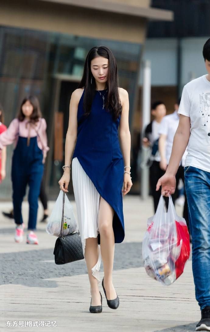 美女穿对半“跳色”连衣长裙，行走间总会有白皙美腿的出现!