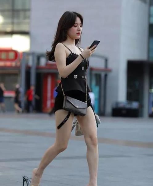  『美女』街拍：皮肤白皙的美女，一件吊带背心配黑色短裤，时尚魅力十足