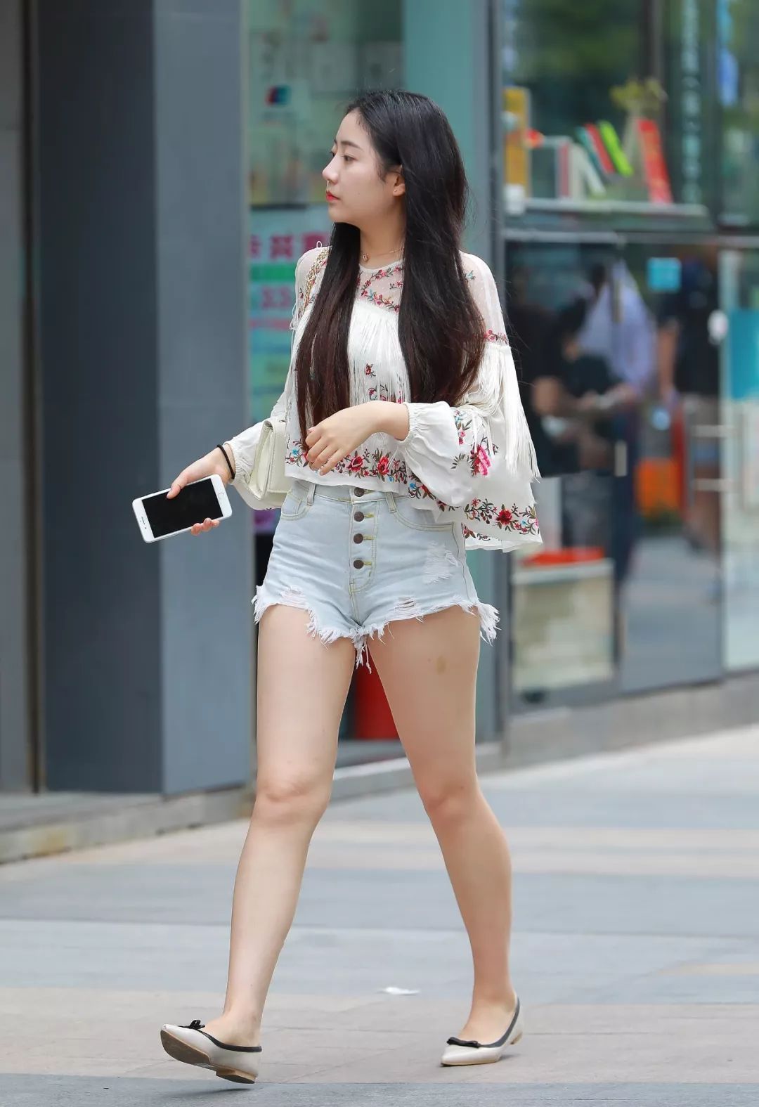 这位小姐姐上衣选择的是一件碎花衫，大腿白皙的肌肤让人尽饱眼福