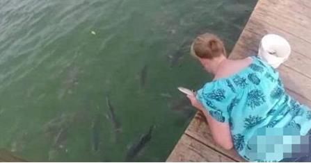 女子池塘边给鱼喂食,朋友叫她赶快离开,接下来