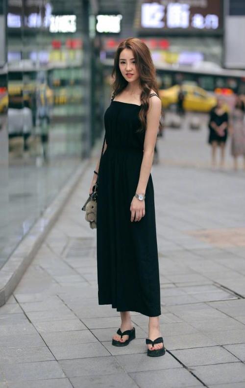 路人街拍，黑色的吊带非常的凸显身材，让小姐姐看上去格外的抢眼