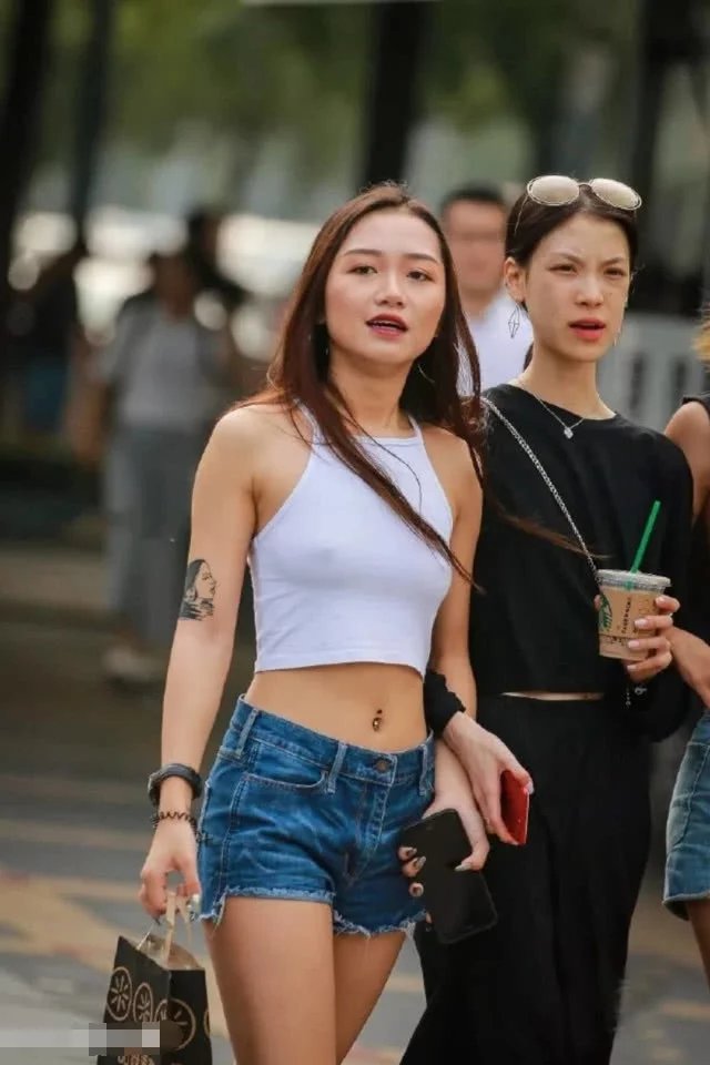 辣妹热裤秀笔直双腿和健美蛮腰，真空穿着背心，时尚又俏皮