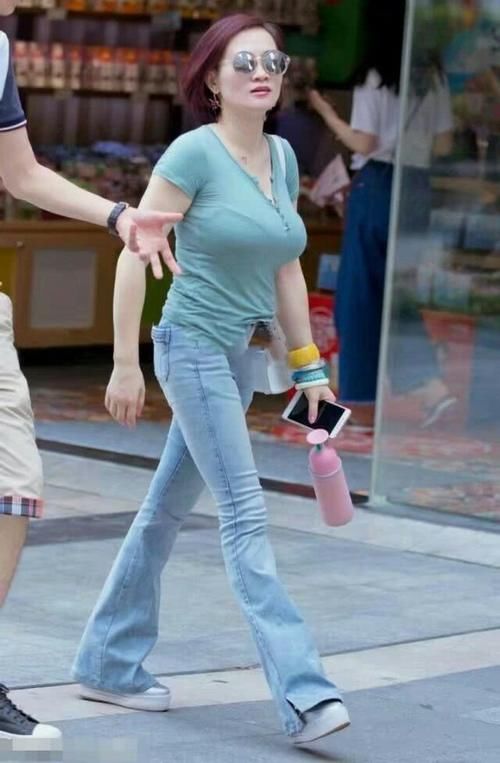 紧身牛仔裤凸显修长大腿，纤纤细腰若隐若现，让你的夏天倍受关注