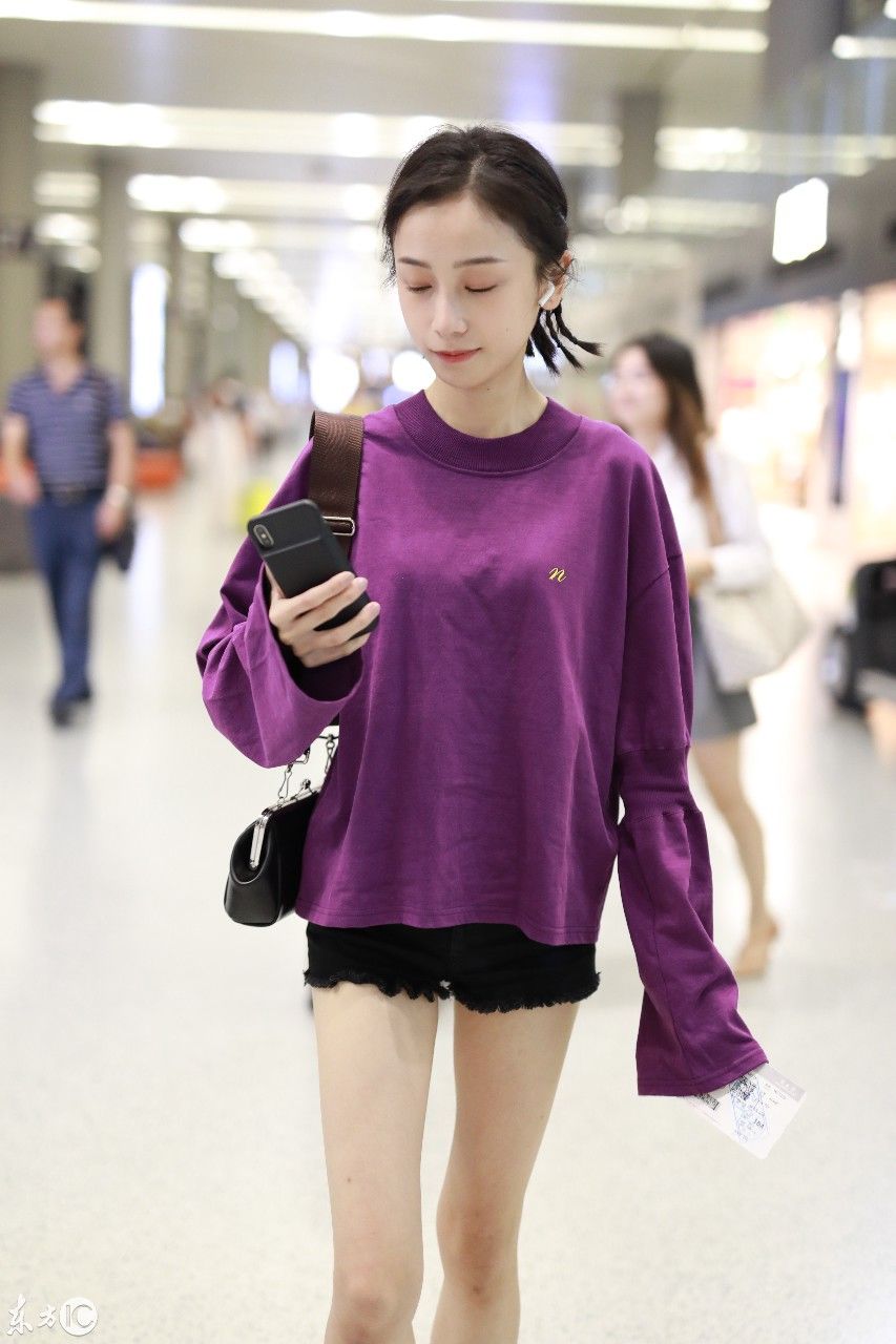 姜梓新穿紫色卫衣搭配黑短裤现身机场，皮肤白皙面带微笑大秀美腿
