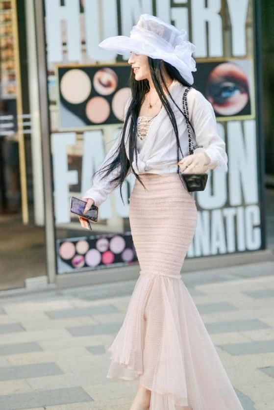 粉色长裙搭配上一顶白色帽子，让女人显得高雅又迷人
