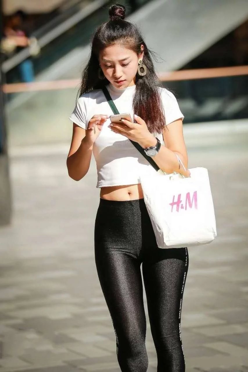 健身女教练黑色紧身运动裤，裹出丰腴的臀线，俏皮的表情吸眼无数