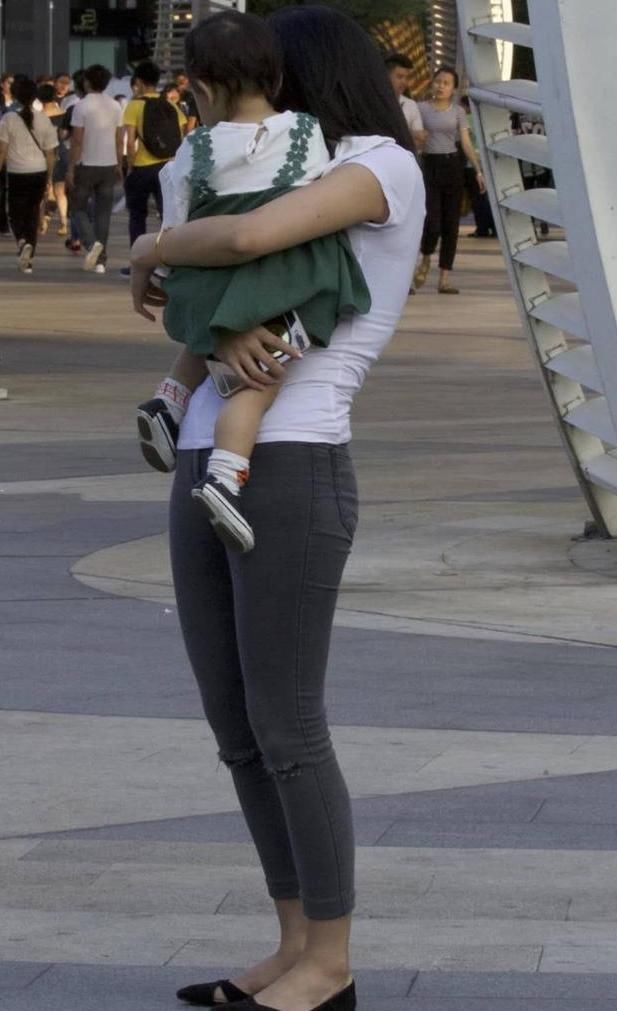 街拍美女：白色的t恤搭配黑色的紧身牛仔裤，辣妈身材很耐看