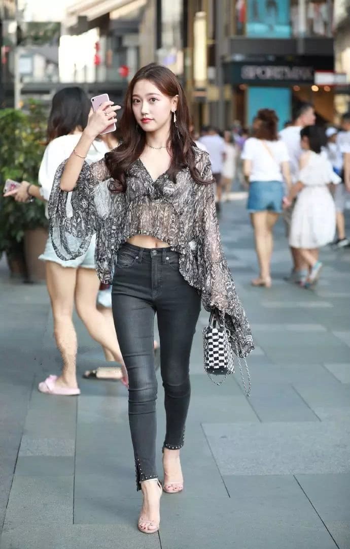 紧身牛仔裤的美女,搭配薄如纱的上衣,美丽又大方,很招人喜欢!