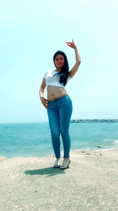 牛仔裤妹子穿高跟鞋太久了，索性光脚与沙滩来一次亲密接触