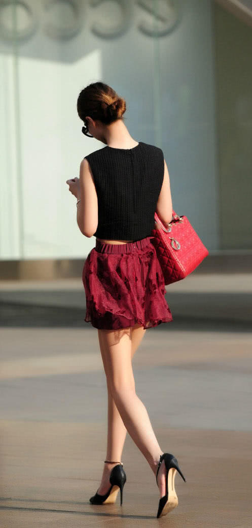 成熟小姐姐穿红色褶皱裙秀出纤长白皙美腿，长腿搭上细高跟很迷人