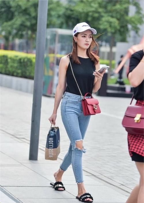  『女性』路人街拍，小姐姐搭配一件黑色背心，展示出女性的活力气息