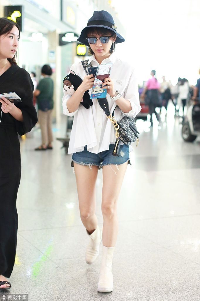 王子文穿白衬衫秀嫩腿大方挥手 戴单个耳坠时尚手指镜头似问路