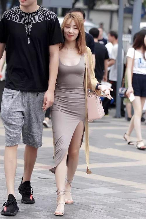 街拍：穿开叉裙露着美腿，和男友逛街的漂亮美女