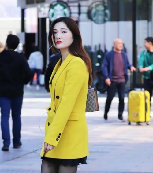  『女人味』养眼女神街拍：肤如凝脂的美女，一件黄色外套配黑色短裙，时尚魅力女人味