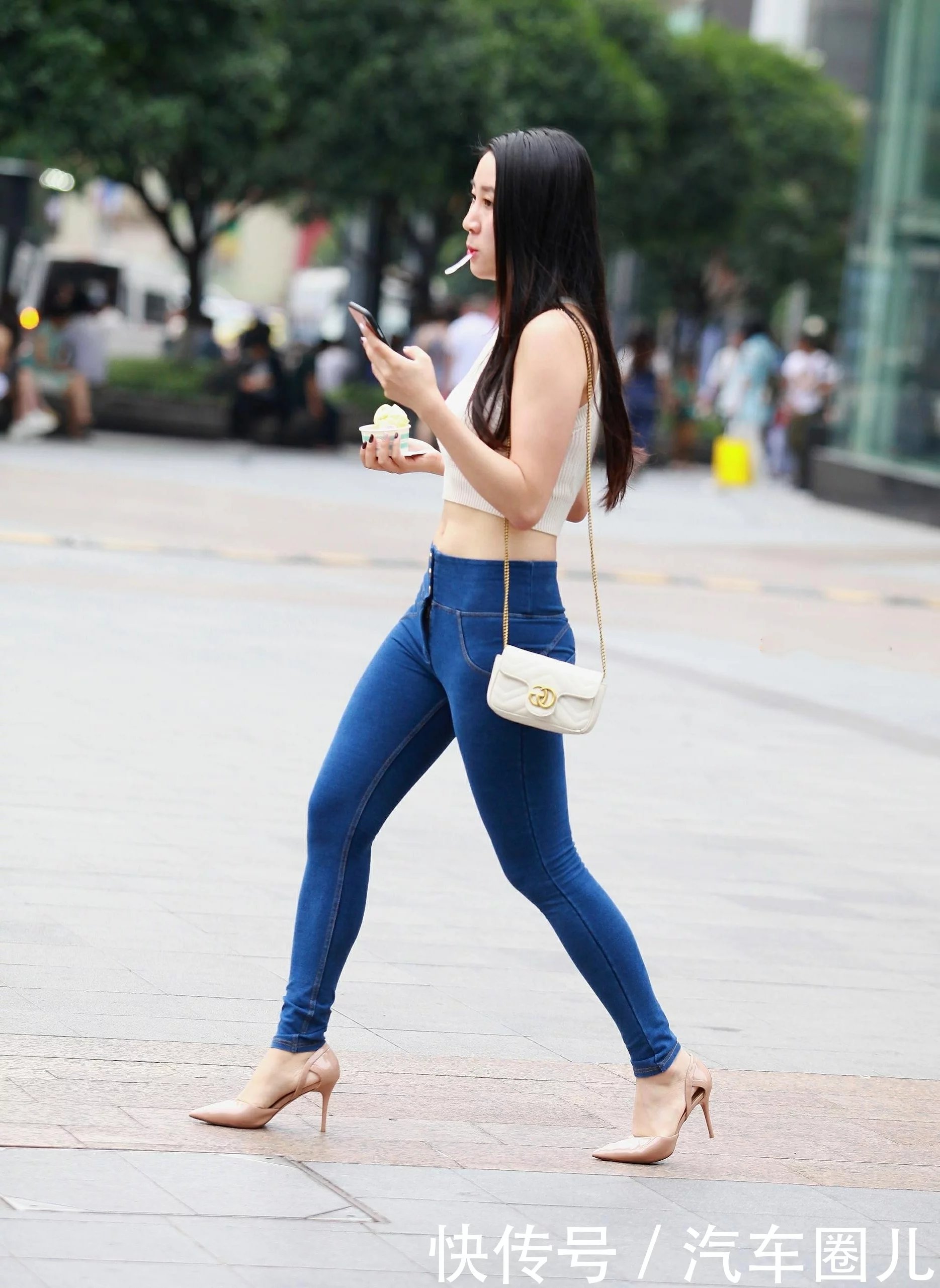 气质小姐姐紧身牛仔裤搭配大气十足，嘴里含着小勺子尽显可爱呆萌