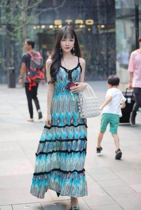 街拍：婴儿肥小姐姐孔雀翎吊带裙显出完美身姿，令人难以移开目光