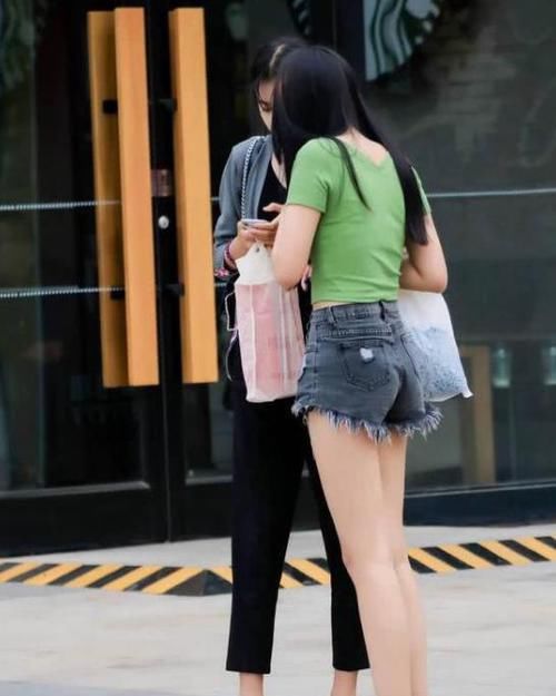  气质：美女时尚街拍：千娇百媚的美女，一件绿色的连衣裙外搭长袖开衫，气质女神
