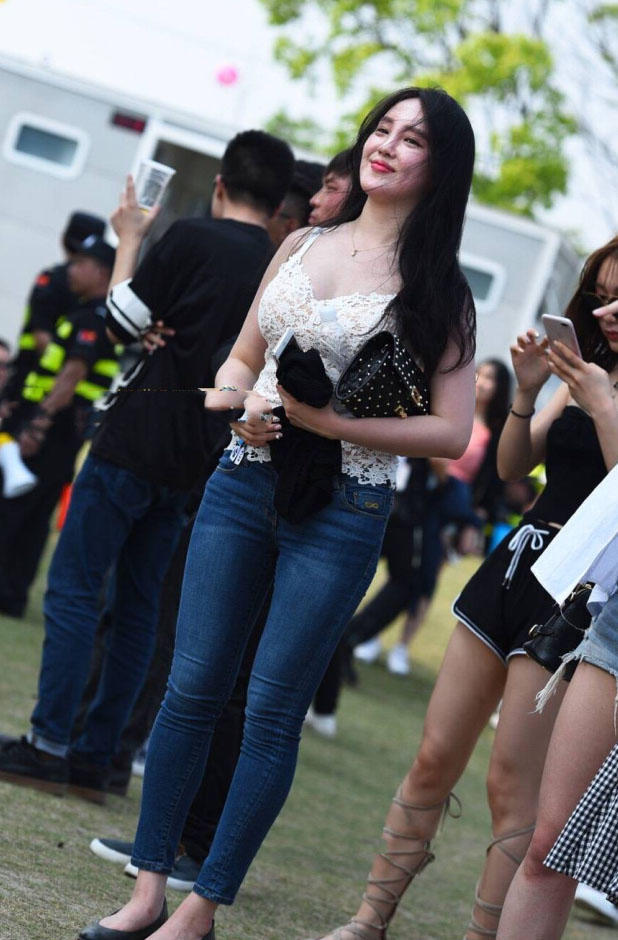 小姐姐在人群中很显眼，上边一件白色的蕾丝吊带，有点镂空的设计