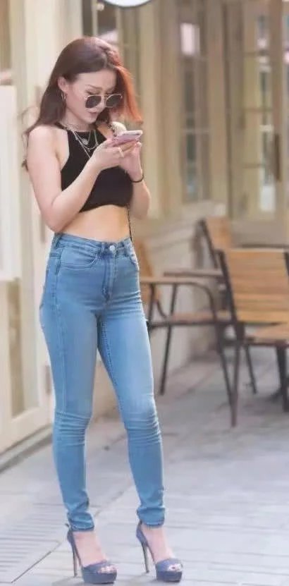 墨镜小姐姐黑色肚脐装裹出丰满上围，牛仔裤大秀修长玉腿，女人味
