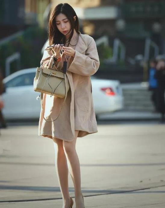 『美女』街拍:面带微笑的美女,一件毛绒外套配米色开叉裙,时尚女神气质