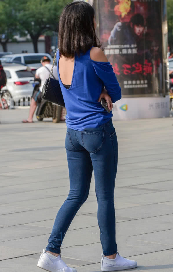 一件蓝色的长袖衬衣，后背的设计也是把小姐姐的内衣给展现了一部