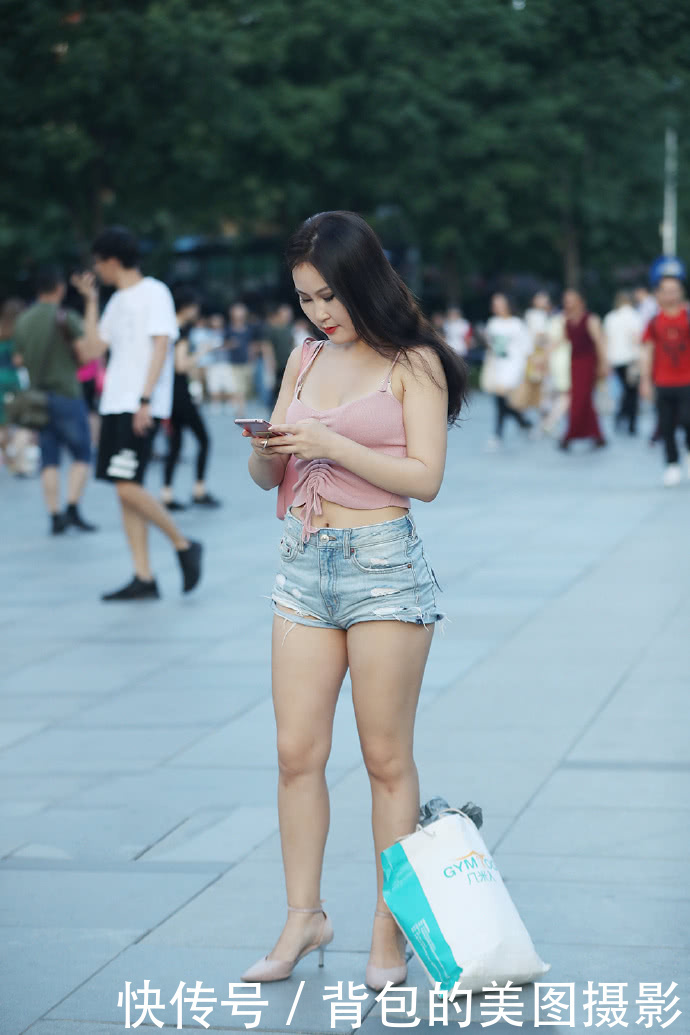 路人街拍，时尚的热裤秀出小姐姐白皙水嫩的肌肤和迷人的大长腿