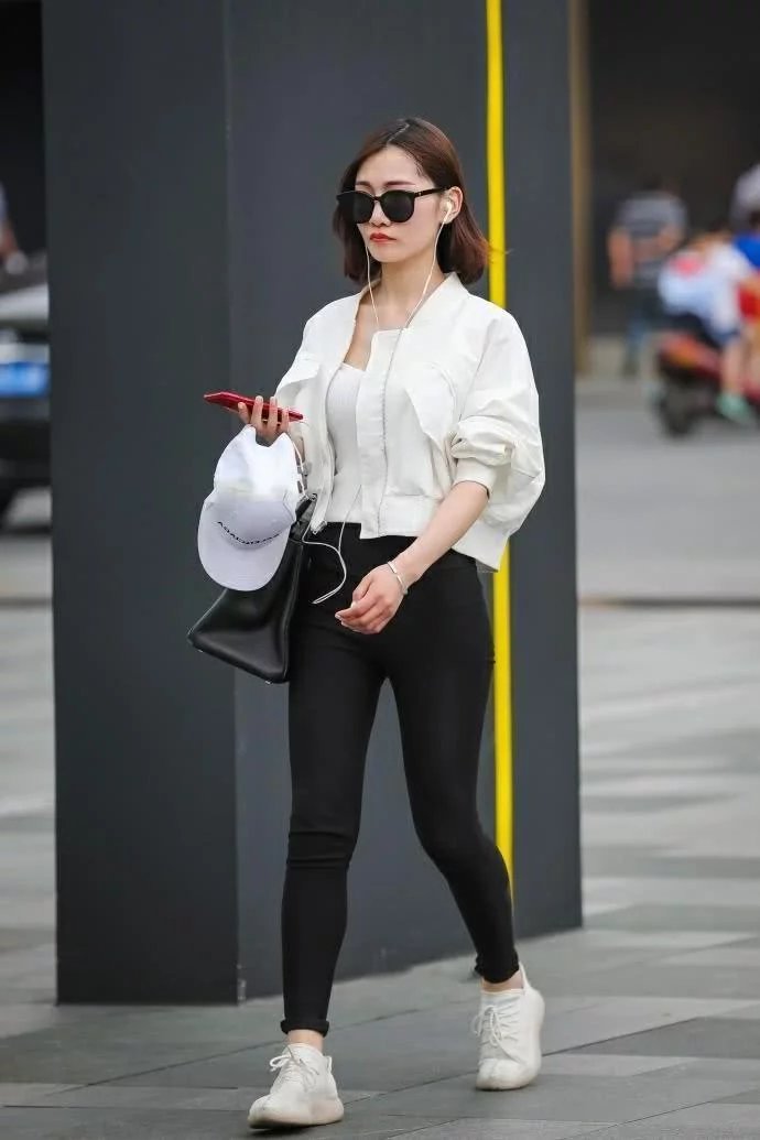 街拍：俏丽小姐姐白色修身背心搭配黑色紧身裤，时尚的穿搭秀出好