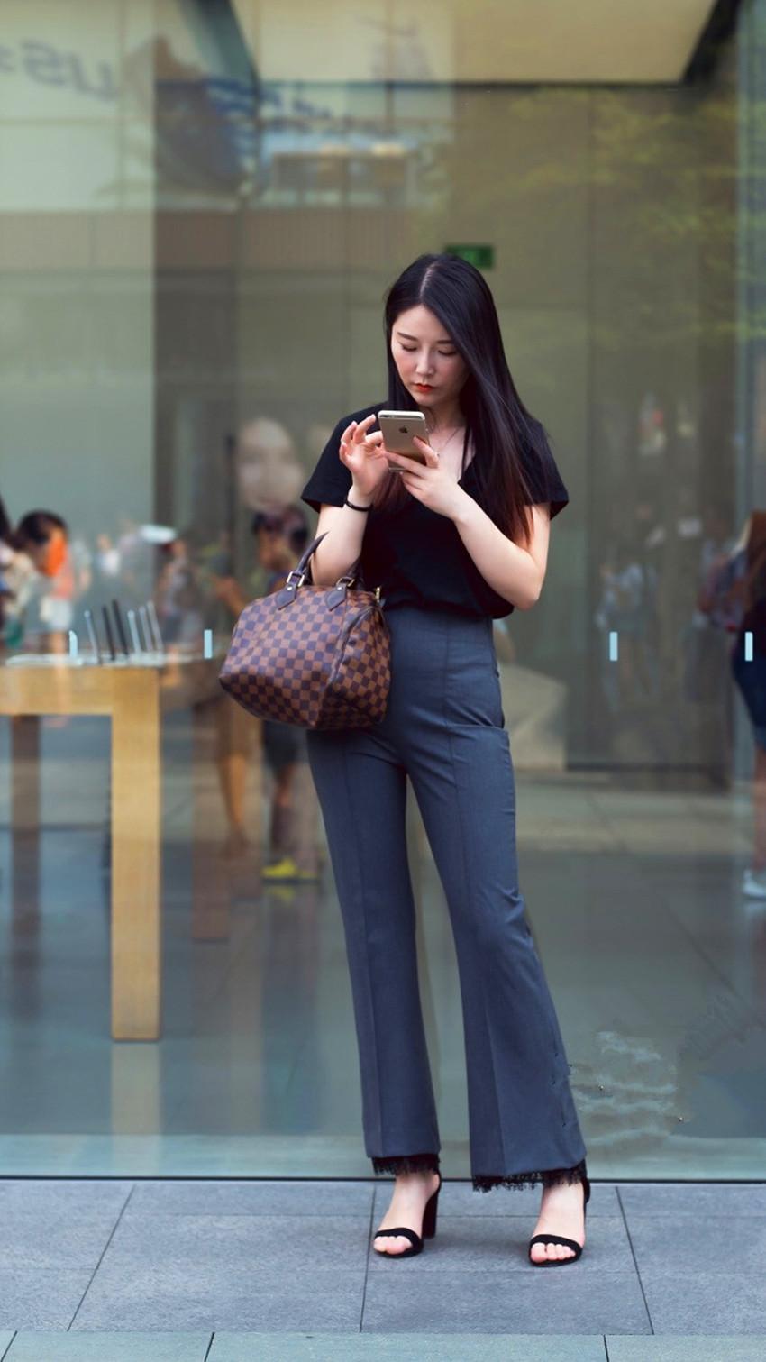 路人街拍，小姐姐身穿一件白色无袖紧身的超短裙，温柔又有女人味