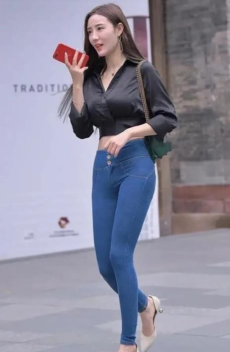  #气质#潮范儿女神来了，街拍：面带笑容的小姐姐，一件黑色上衣配蓝色牛仔裤，女神气质范