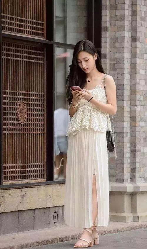  『优雅』街拍：小姐姐一件蕾丝的吊带搭配米白色的百褶裙，尽显时尚魅力