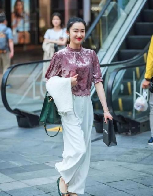  #休闲裤#街拍：面带笑容的小姐姐，一件紫色上衣配白色休闲裤，时尚魅力