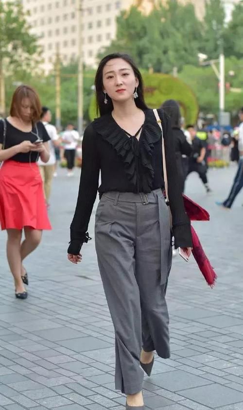  [搭配一双]街拍：小姐姐上衣采用了大V领的设计，非常的显脸小，显气质