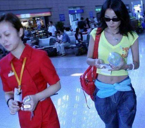 48岁王菲现身机场, 露脐装一片哗然, 网友: 丝巾当腰带够大胆!