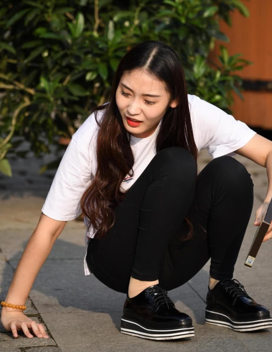 街拍:小姐姐盘腿坐在路边,紧身裤太紧绷,刚一起身差点儿没摔倒
