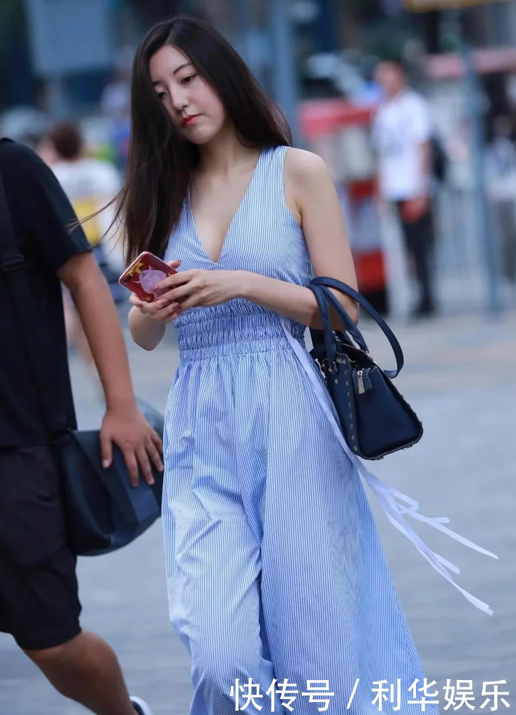 气质小姐姐身深V蓝色连衣裙十分性感，给人们一种特殊的美感