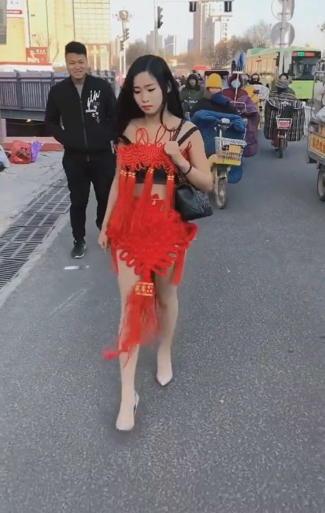 美女披着中国结衣服走在街头，路人表示大开眼界