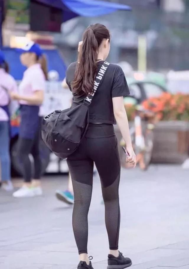 紧身裤小辣妹显凹凸线条，低头玩手机成了一道时尚风景线
